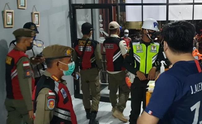 Anggota Satpol PP di Sumsel menegakkan aturan PPKM dan mengedukasi masyarakat.